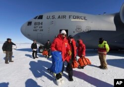U.S. Secretary of State John Kerry, center, disembarks from a U.S. Air Force C17 Globemaster with the National Science Foundation's Scott Borg, right, at the Pegasus ice runway near McMurdo Station, Antarctica on Nov. 11, 2016.