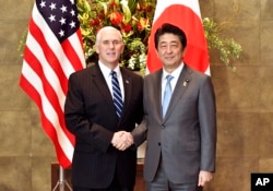 U.S. Vice President Mike Pence, left, shakes hands with Japan's Prime Minister Shinzo Abe upon his arrival at the prime minister's official residence in Tokyo Wednesday, Feb. 7, 2018.