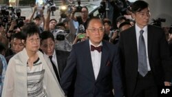 Donald Tsang, center, former leader of Hong Kong and his wife Selina arrive at a magistrates' court in Hong Kong Monday, Oct. 5, 2015.