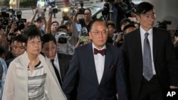 Donald Tsang, center, former leader of Hong Kong and his wife Selina arrive at a magistrates' court in Hong Kong Monday, Oct. 5, 2015.