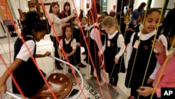 FILE - Girls from a city preparatory school play with an interactive exhibit at the National Museum of Mathematics in New York.