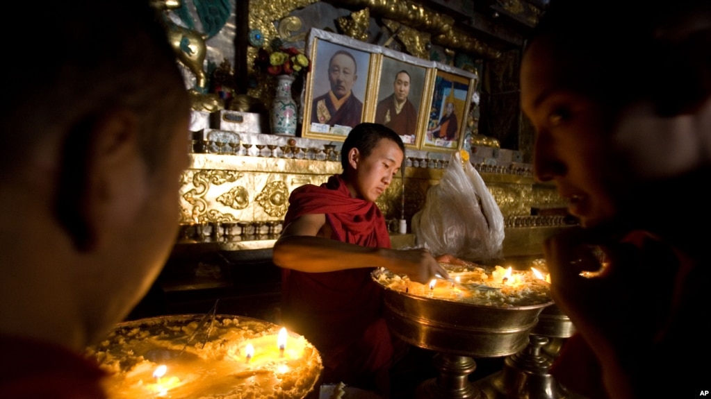 西藏日喀则扎什伦布寺的僧侣2019年7月19日在点亮寺庙松油。