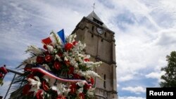 Flowers pay tribute to French priest Father Jacques Hamel outside the parish church at Saint-Etienne-du-Rouvray, near Rouen, France, July 28, 2016. Father Jacques Hamel was killed on Tuesday in an attack on the church that was carried out by assailants linked to Islamic State. 