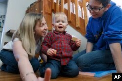 Anna Ford, left, and her partner, Sara Watson, play with their son, Eli, at home in the village of Saunderstown, in Narragansett, R.I., Nov. 16, 2018.