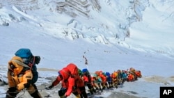 Antrean panjang pendaki gunung berbaris di jalan setapak di Gunung Everest tepat di bawah kamp empat, di Nepal. (Foto: AP)