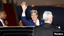 Ngoại trưởng John Kerry vẫy chào các nhà báo sau khi đặt chân tới sân bay quốc tế Phnom Penh hôm 25/1. 
