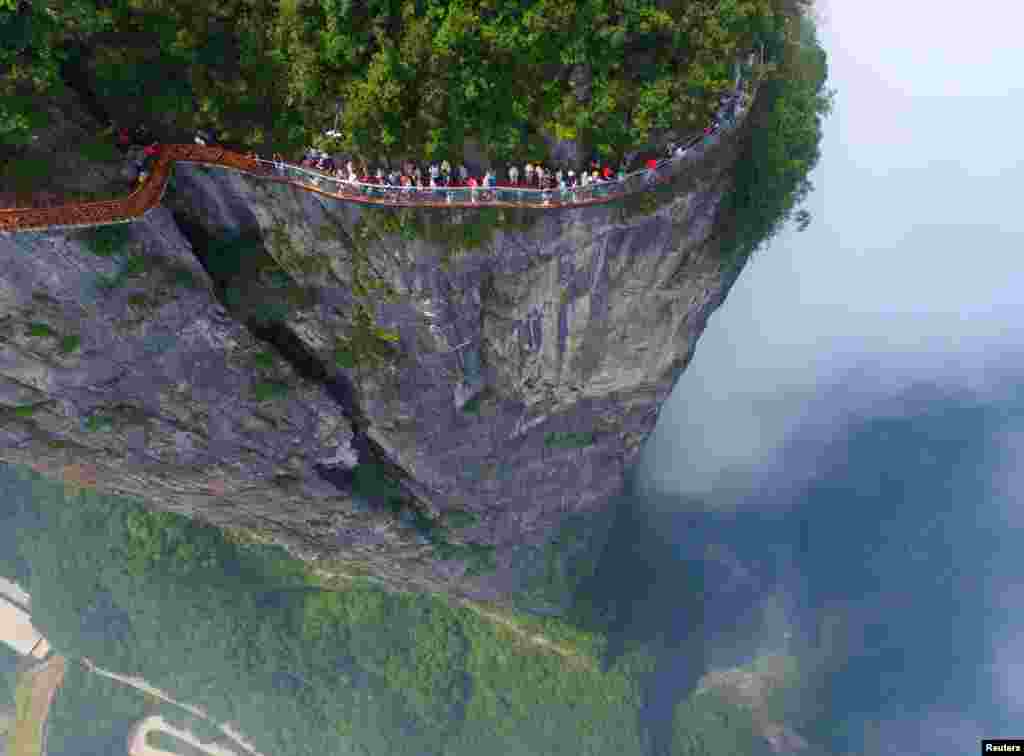 People walk on a sightseeing platform in Zhangjiajie, Hunan Province, China, Aug. 1, 2016.