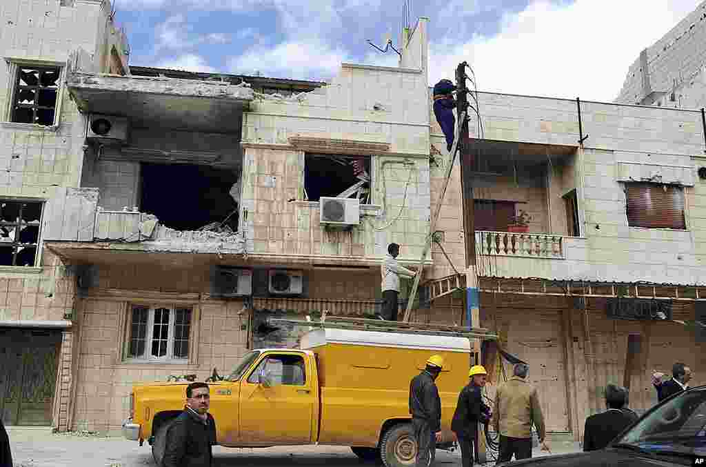 This handout photo shows workers at buildings SANA says were destroyed by opposition forces in Baba Amr, Homs, March 14, 2012. (Reuters/SANA)