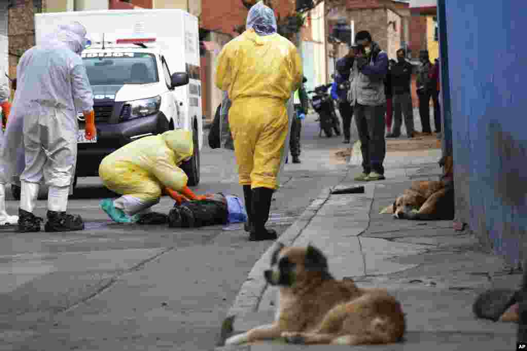 Health workers recover the body of a street vendor who was found dead at dawn by his neighbors in the Cerro San Miguel neighborhood of Cochabamba, Bolivia, July 25, 2020.