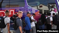 ARCHIVO - Migrantes venezolanos esperan en línea para abordar un autobús en El Paso, Texas, el 2 de septiembre de 2022.