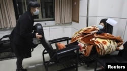 Seorang pasien yang menderita demam dirawat di rumah sakit di kota Hangzhou, provinsi Zhejiang (3/4). Periset China mengatakan virus H7N9 berjangkit dari unggas ke manusia. 