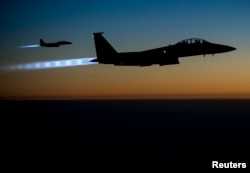 FILE - A pair of U.S. Air Force F-15E Strike Eagles fly over northern Iraq after conducting airstrikes in Syria, in this U.S. Air Force handout photo.