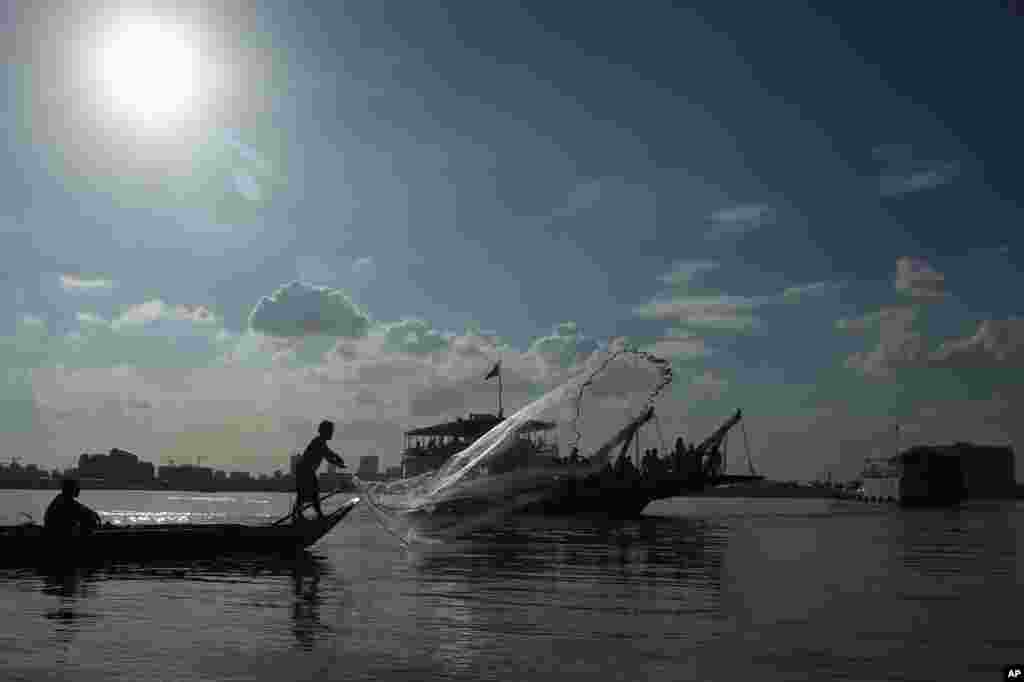 Seorang nelayan menebarkan jalanya di sungai Mekong dekat Phnom Penh, Kamboja.