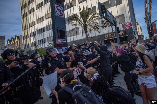 Demonstrators try to block Police officers while they take position aiming towards the crowd