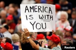 A supporter holds a sign during a rally with President Donald Trump at the U.S. Cellular Center in Cedar Rapids, Iowa, June 21, 2017.