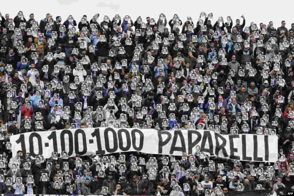 Lazio&#39;s fans hold portraits and a banner remembering Vincenzo Paparelli, a Lazio&#39;s fan killed by a flare in 1980, during the Italian Serie a football match Benevento Calcio vs SS Lazio at the Ciro Vigorito Stadium in Benevento, Italy.