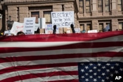 FILE - Demonstrators gather outside the Texas State Capitol in an attempt to influence the Republican electors from across the state to not vote for Donald Trump when they cast their formal ballots for president of the United States in Austin, Texas, Dec. 19, 2016.