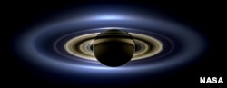 On July 19, 2013, NASA's Cassini spacecraft moved into Saturn's shadow and took this image the planet, seven of its moons, its inner rings -- and, in the background, our Earth.