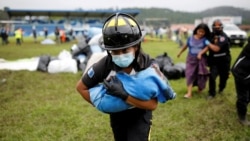 Um bombeiro carrega um bebé de uma área de deslizamento de terras, causado pelo furacão Eta, San Cristobal Verapaz, Guatemala, Nov. 7, 2020.