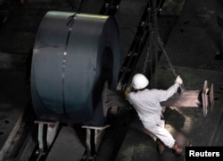 FILE - An employee works at the Baosteel Group Corp. factory in Shanghai.