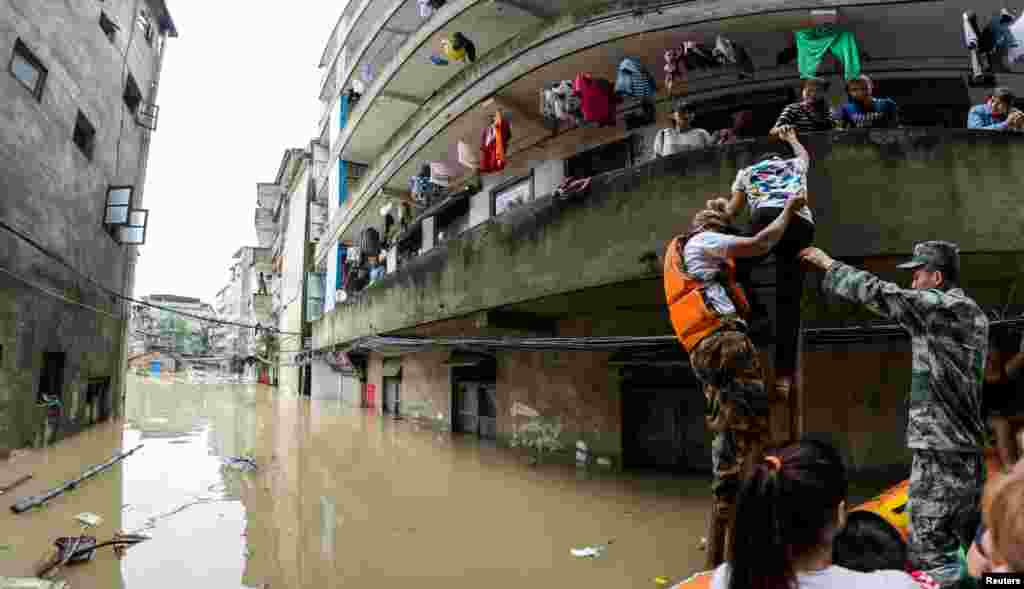 Tim penyelamat memindahkan penduduk dengan kapal di daerah yang terkena banjir di Guilin, provinsi Guangxi, China, 2 Juli 2017.