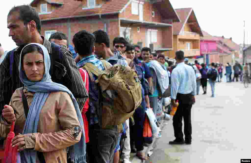 Migrants wait for a meal offered to them for the celebration of Eid-al-Adha in the village of Miratovac near the town of Presevo, southern Serbia, Sept. 24, 2015.