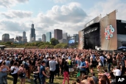 Fans watch performances at Lollapalooza in Grant Park, Aug 6, 2017 in Chicago. According to reports, the Las Vegas gunman also reserved rooms in Chicago, overlooking the Lollapalooza festival, but he did not check in.