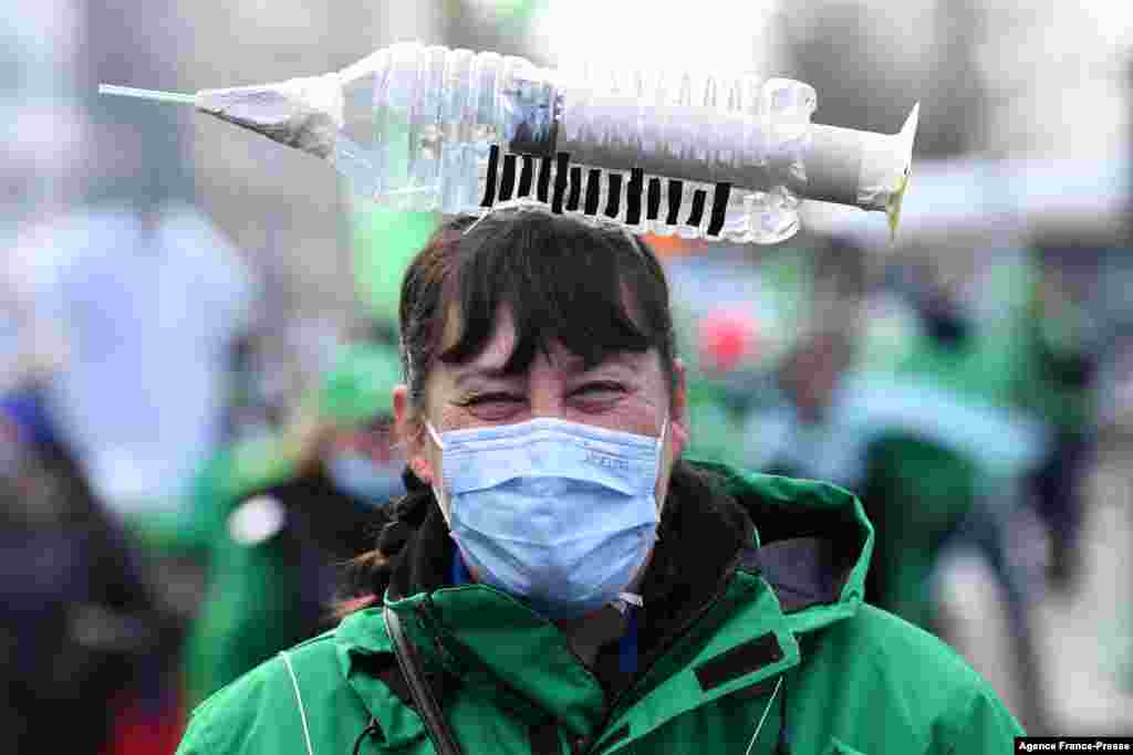 A health care worker takes part in a trade union demonstration against required COVID-19 vaccination in Brussels, Belguim.