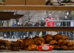 People wearing masks gather to form a "bread" line at Bread Alone outdoor market, while maintaining social distancing requirements during the COVID-19 outbreak April 4, 2020 in New York. (AP Photo/Bebeto Matthews)