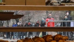 People wearing masks gather to form a "bread" line at Bread Alone outdoor market, while maintaining social distancing requirements during the COVID-19 outbreak April 4, 2020 in New York. (AP Photo/Bebeto Matthews)