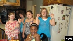 Madison Blandford (far left) and her classmates and neighbors show off their Ugandan beads at Madison's recent jewelry party. (VOA/F. Elmasry)