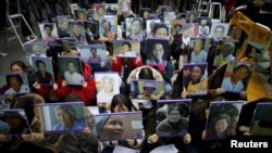 Students hold portraits of deceased former South Korean "comfort women" during a weekly anti-Japan rally in front of Japanese embassy in Seoul, South Korea, December 30, 2015. 