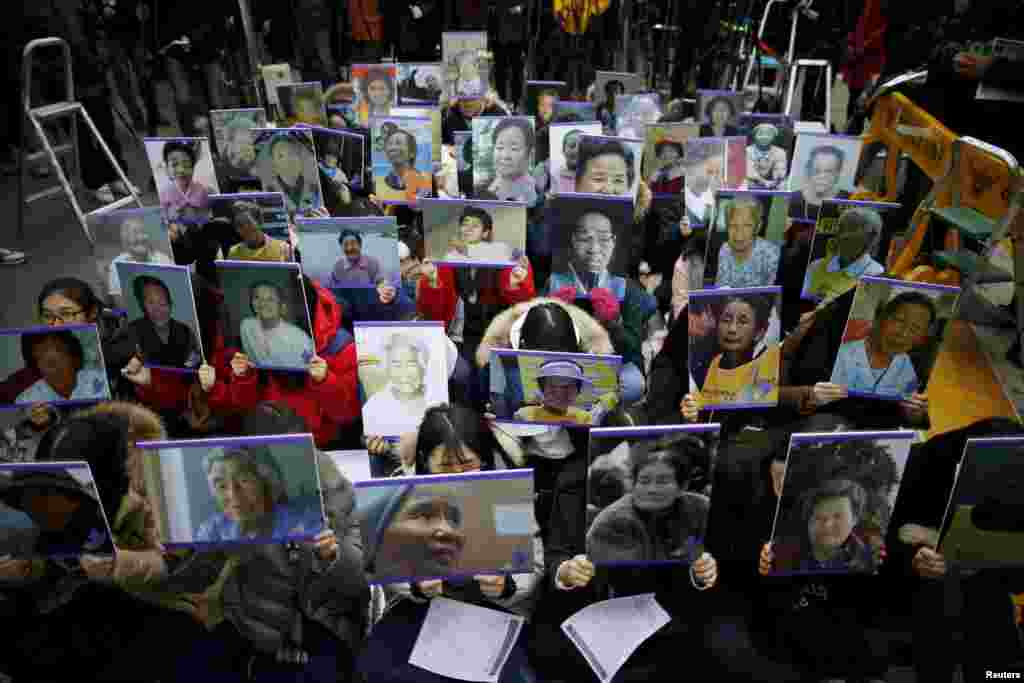 Para siswa memegang potret mendiang mantan &quot;wanita penghibur&quot; Korea Selatan saat pawai anti-Jepang di Seoul, Korea Selatan, 30 Desember 2015.