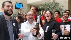 Rolando Jimenez, a spokesman for LGBT rights group Movilh, holds a champagne bottle and celebrates with group members after the Chilean Congress passed a bill recognizing civil unions in Valparaiso, Chile, Jan. 28, 2015.