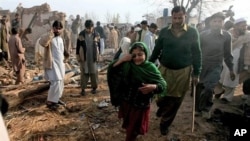 A Pakistani girl whose father is injured in a car bomb blast which killed many people, walks at the site of explosion in suburbs of Peshawar, Pakistan, February 02, 2011.