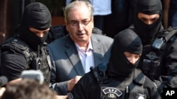 FILE - Eduardo Cunha, former speaker of Brazil's lower house, is escorted by federal police officers as he arrives to the Legal Medical Institute, in Curitiba, Brazil, Oct. 20, 2016. 