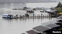 Tourists and gamblers disembark a boat on the Mekong River near the Thai port of Chiang Saen in the Golden Triangle region where the borders of Thailand, Laos, and Burma meet January 14, 2012. 