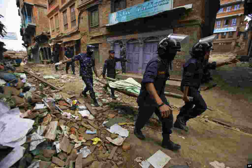 A equipa de resgate nepalesa transporta o corpo de uma vítima recuperada dos escombros de um edifício que ruiu depois do terramoto em Bhaktapur, perto de Katmandu, Nepal.