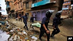 네팔 구조대원들이 26일 카투만두에서 무너진 건물 잔해 속에서 회수한 희생자 시신을 옮기고 있다.