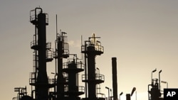 Towers and smokestacks are silhouetted at an oil refinery in Melbourne (2010 file photo)