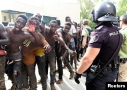 African immigrants celebrate as they enter the immigrant center CETI in the Spanish enclave Ceuta, after some 200 refugees crossed the border fence between Morocco and Ceuta, Aug. 22, 2018