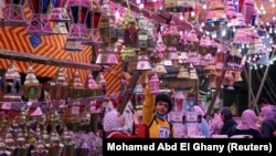 Orang-orang mengambil foto lentera Ramadhan tradisional yang disebut "fanous" di sebuah kios toko menjelang bulan suci Ramadhan, di tengah pandemi COVID-19 di Kairo, Mesir, 8 April 2021. (Foto: REUTERS/Mohamed Abd El Ghany )