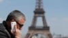 A man makes a phone call using his mobile phone at the Trocadero Square near the Eiffel Tower in Paris, May 16, 2014. 