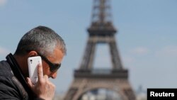 مردی در حال گفتگو با تلفن همراه در ميدان تروکادروی پاريس، نزديک برج ايفل -- ۲۸ ارديبهشت (۱۶ مه ۲۰۱۴)