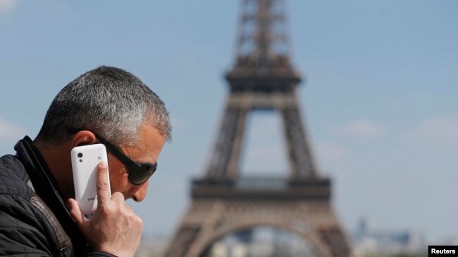 一名男子在巴黎埃菲尔铁塔前打电话。2014年5月16日
