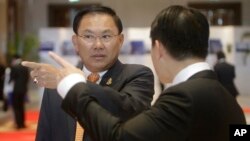 Cambodian business tycoon Ly Yong Phat, left, waits for Cambodia's Prime Minister Hun Sen to arrive for the Cambodia-China Business and Investment Forum at the outskirt of Phnom Penh, Cambodia, Thursday, Dec. 1, 2016. (AP Photo/Heng Sinith)