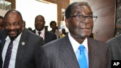 FILE: Zimbabwe's President Robert Mugabe, right, arrives for the heads of state meeting of the annual African Union (AU) summit, held at the AU headquarters in Addis Ababa, Ethiopia, Jan. 30, 2015. 