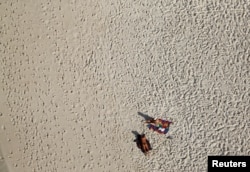 An aerial view shows people on Barra da Tijuca beach in Rio de Janeiro, Brazil, July 16, 2016.