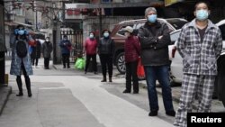 Banorët presin në radhë të barazlarguar nga njëri-tjetri, për të marrë ushqime (Hubei, Kinë)
