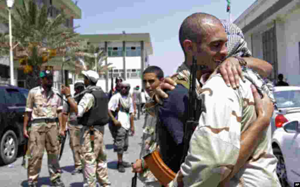 Libyan rebel fighters embrace at the former female military base in Tripoli, Libya. Libyan rebels claimed to be in control of most of the capital on Monday, but scattered battles erupted and Gadhafi's whereabouts remained unknown, Aug. 22, 2011. (AP)